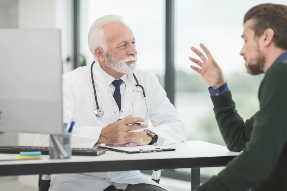 A specialist listening to a patient during a consultation