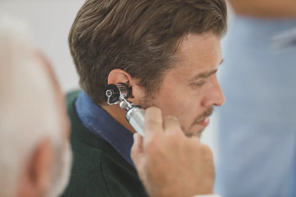 Close-up of an ear being examined with an otoscope